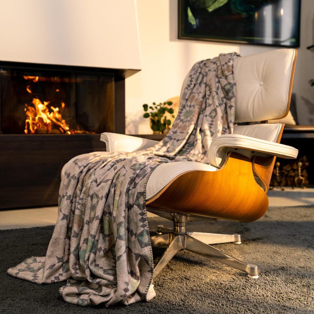 Kayori Ziane plaid met een meerkleurig dessin over een lichte fauteuil.