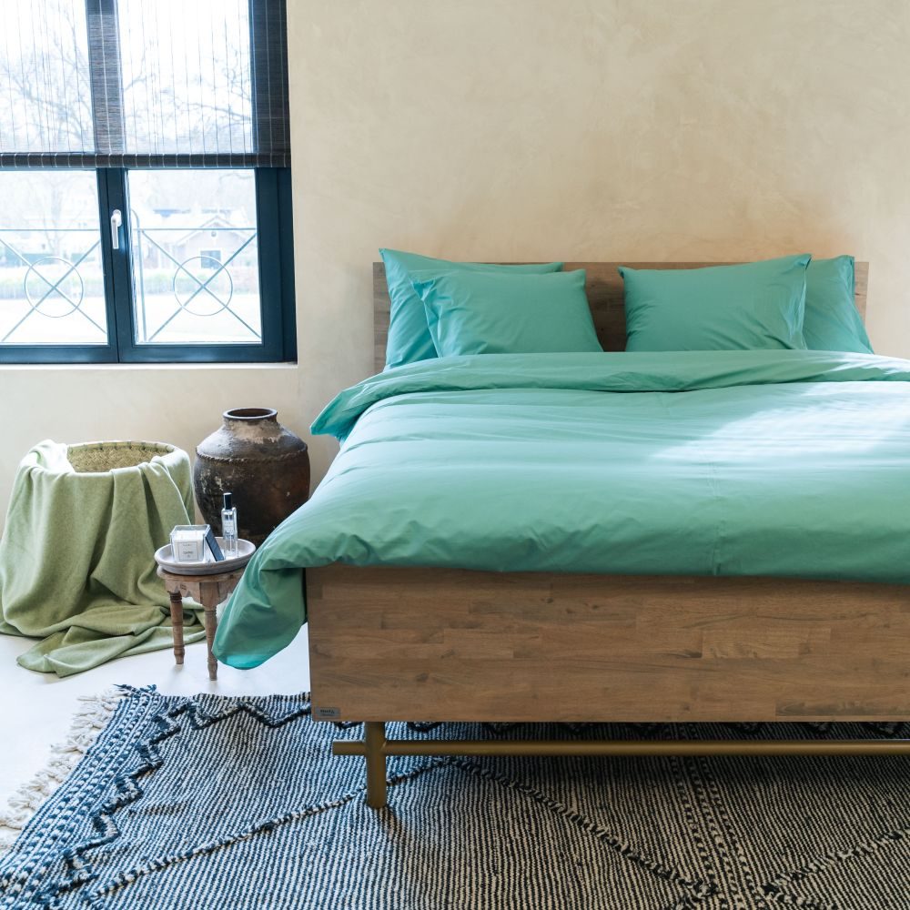 Bed met het groene Kayori Shizu dekbedovertrek en bijpassende kussenslopen.